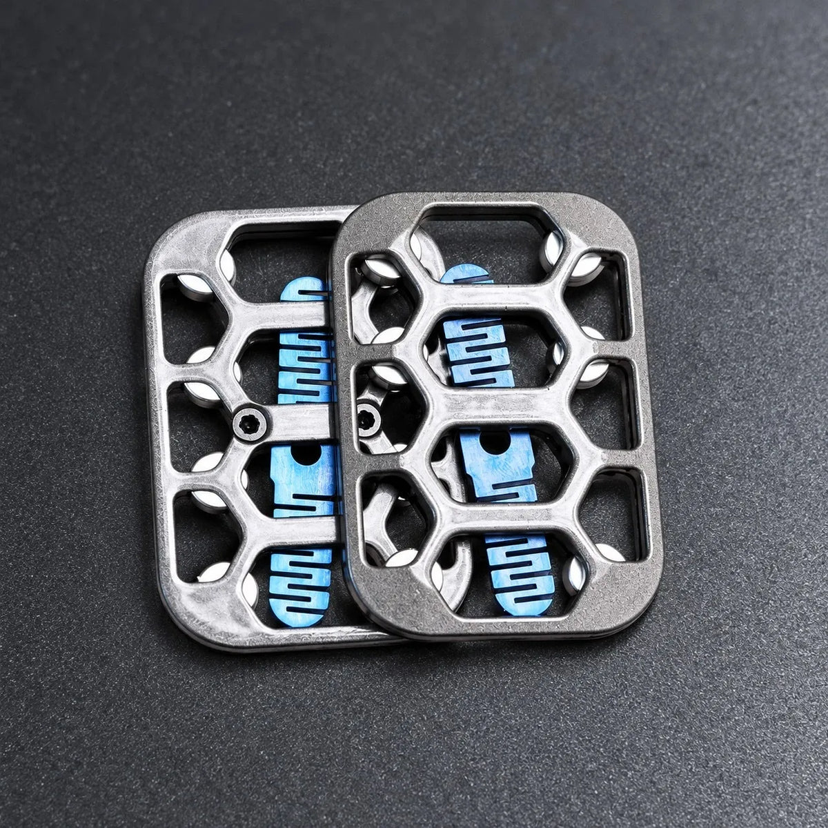 Hollow magnetic fidget slider in black and gunmetal on a bead-blasted steel desk