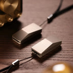 THE CYBER fidget slider — wedge body, one closed one open, on a wood desk