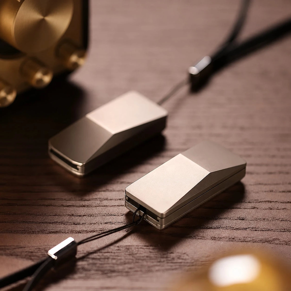 THE CYBER fidget slider — wedge body, one closed one open, on a wood desk