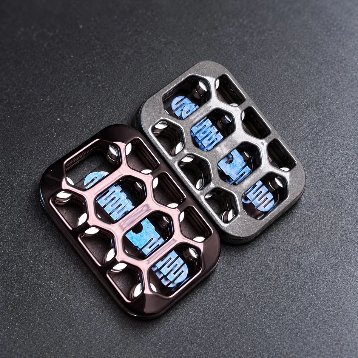 Magnetic fidget slider — black and silver plates, angled on a bead-blasted steel desk